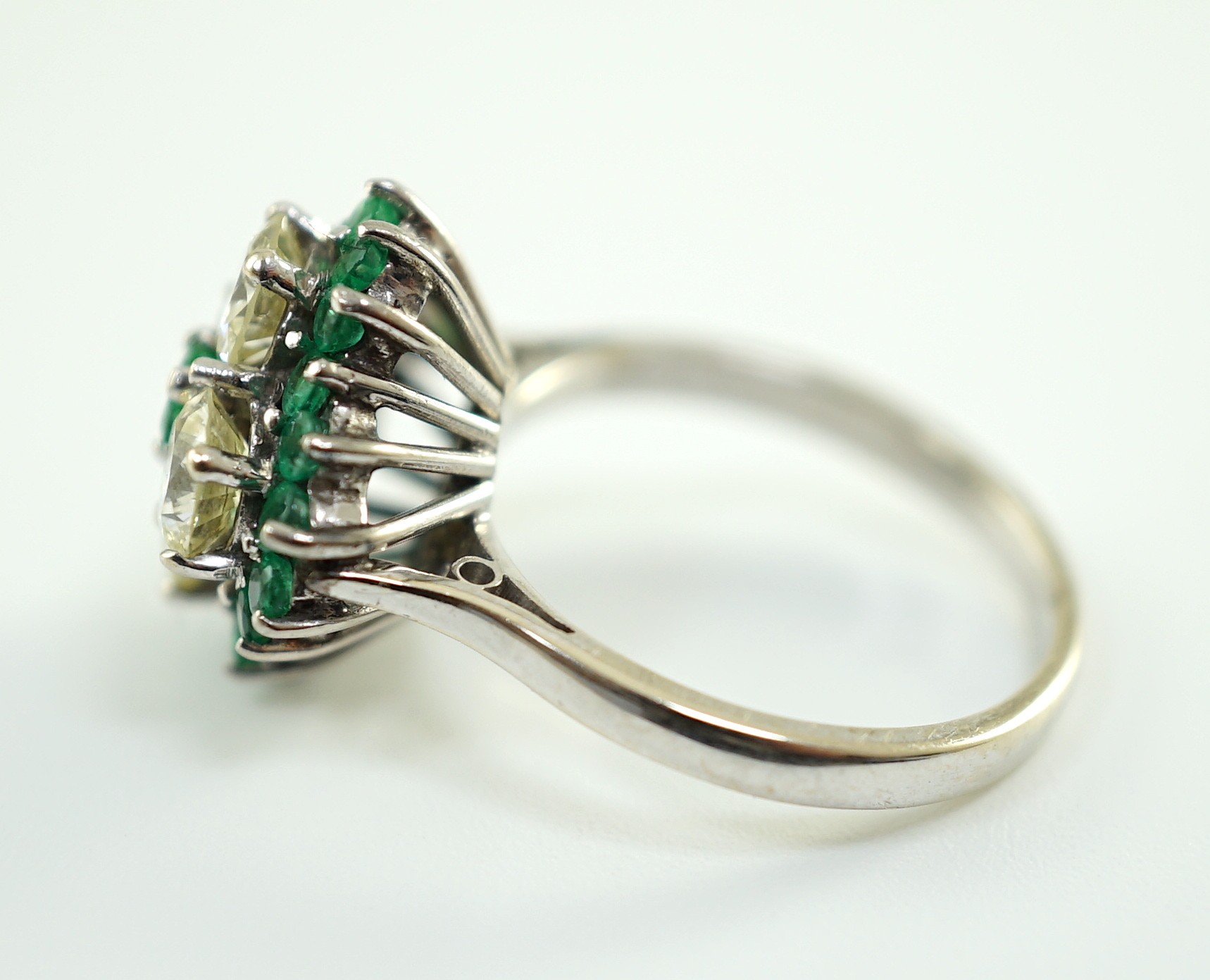 An 18ct white gold, emerald and diamond cluster set dress ring